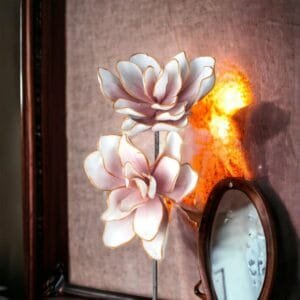 Zwei kunstvolle Blumen vor dekorativem Hintergrund.