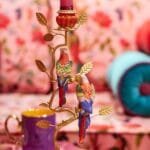 5165-Kerzenleuchter-Papageien-rot-gold-Polyresin-Metall-9x16x33-B74046_2.jpg Bunter Kerzenhalter mit Papageien im Retro-Stil, florale Hintergrunddetails.